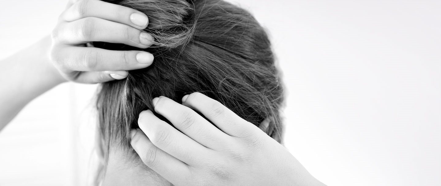 Een vrouw krabt aan haar jeukende hoofdhuid